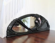 a large mirror sitting on top of a hard wood floor next to a stair case