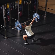 a man squats on one leg while lifting a barbell