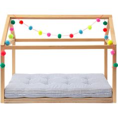 a wooden bed frame with multicolored pom - poms on the top