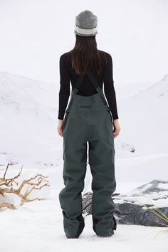 a woman standing in the snow with her back to the camera