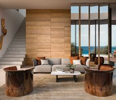 a living room filled with furniture next to a window covered in glass and wooden panels