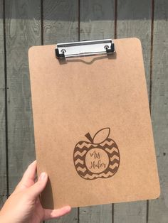 a hand holding a clipboard with an apple on it that says, my teacher