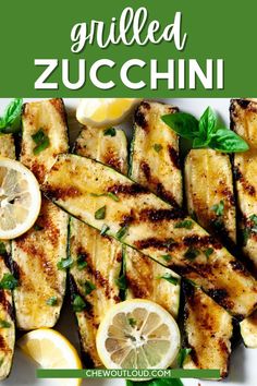 grilled zucchini with lemons and herbs on a white platter text overlay reads grilled zucchini