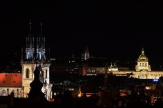 the city skyline is lit up at night with lights on it's spires