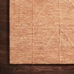 an orange rug on top of a wooden floor