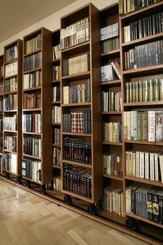 a large bookshelf filled with lots of books on top of hard wood floors