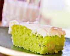 a piece of green cake sitting on top of a plate next to a glass of milk