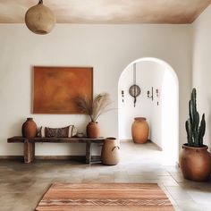 a room with some plants and vases on the floor