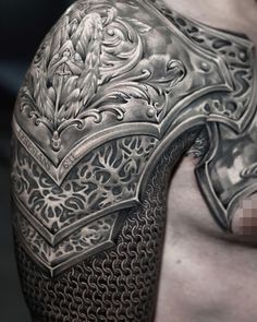 a man's arm with an intricate tattoo design on the shoulder and chest area