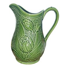 a green vase with leaves on it