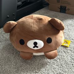 a brown teddy bear pillow sitting on the floor