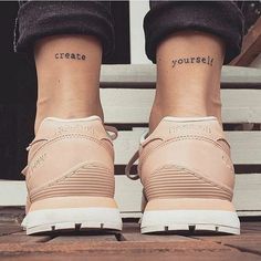 two people with small tattoos on their feet and one has the words create yourself written on them