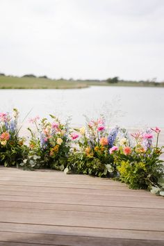 colorful flowers line the edge of a wooden deck