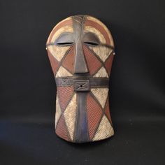 an african mask is shown against a black background with the image of a cross on it