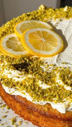 there is a cake with lemons and pistachio on the top, topped with icing