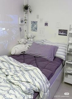 there is a bed with purple sheets and pillows on top of it in the room