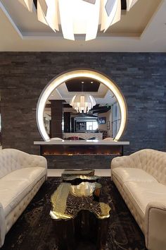 a living room with two couches and a coffee table in front of a circular window