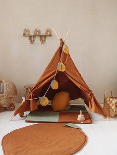 a teepee tent sitting on top of a floor next to a rug and toys