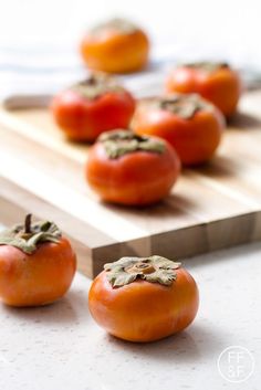 several tomatoes are sitting on a cutting board