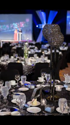 the tables are set up for an event with crystal centerpieces and place settings