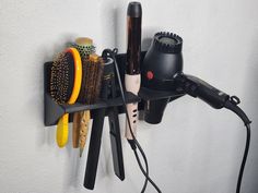 "This compact wall-mounted organizer can hold a blow dryer with extensions, a curling iron, straightener, and 3 brushes! The sizes of each hole are big enough to accommodate most sizes of each hajr tool you might have. If need be, I can modify the design and make the holes bigger to fit your particular hair tool. Whether you're a hair salon owner, or just someone looking to organize your hair-dressing tools, this multi-purpose organizer will help you do that in a convenient way! Ideal for home use, salon use, and as a gift for anyone who needs a small and compact accessory. This organizer is 3D printed and has been designed specifically for durability. This has been tested with many different sizes, shapes, and weights of various blow dryers and other hair tools to make sure it's sturdy en Straightener Holder, Dressing Tool, Hair Accessories Holder, Salon Hair Dryer, Hair Tool Organizer, Blow Dryers, Salon Owner, Hair Dressing, Salon Gifts