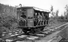 an old black and white photo of people riding in a train car on the tracks