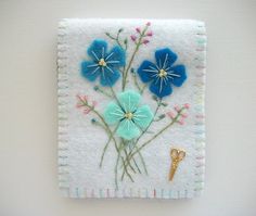 an embroidered piece with flowers on it and a pair of scissors