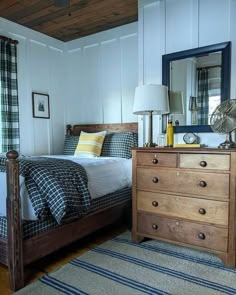 a bed room with a neatly made bed and a dresser