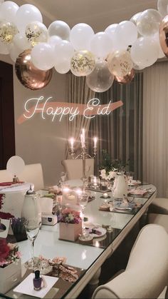 a dining room table with balloons and candles on it for a happy edd party