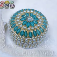 a blue and white box sitting on top of a table next to other jewelry items