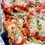 several slices of pizza sitting on top of a pan covered in cheese and spinach