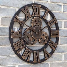 a clock on the side of a brick wall with roman numerals and gears