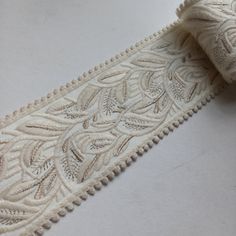 a close up of a white ribbon with intricate designs on the edge and bottom side