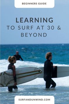 two people carrying surfboards in the ocean with text reading learning to surf at 30 & beyond