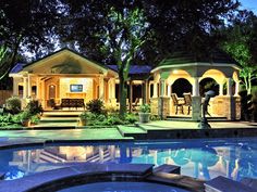 a house with a pool and gazebo lit up at night