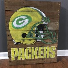 a green bay packers helmet painted on a wooden pallet