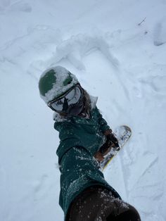 a snowboarder is standing in the snow with his feet up and one hand on his board