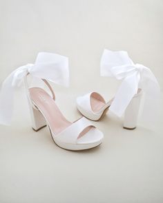 Satin block heel sandal with wrapped satin/sheer ankle tie. Elegance and classic inspired wear for your special day. Perfect for brides, bridesmaids, prom night, date night, and definitely a highlight on every special occasions.DETAILS:HEELS: 4 inchesCOLORS AVAILABLE: Ivory, White and Light BlueUPPER: Synthetic upper and liningMATERIALS: Manmade outsoleORIGIN: ImportedSTYLE NAME: ATHENA Tie Up Shoes, Pretty White Heels, Bridal Shoes With Bows, White Ankle Wrap Heels, Cute Prom Shoes, Graduation Heels College, White Heels With Bow, White Heels With Bow For Events, Summer White Heels With Satin Bow