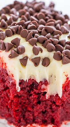 a red velvet cake with white frosting and chocolate chips