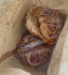 two cinnamon buns in a brown paper bag