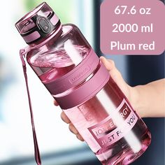 a person holding a pink water bottle in their hand