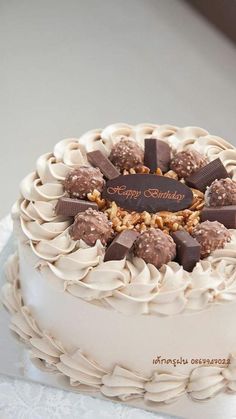 a white cake with chocolate and nuts on top