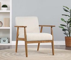 a white chair sitting on top of a wooden floor next to a potted plant