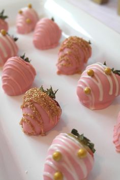 pink and gold strawberries are arranged on a white platter