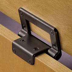 a close up of a metal door handle on a wooden cabinet with purple tape around it