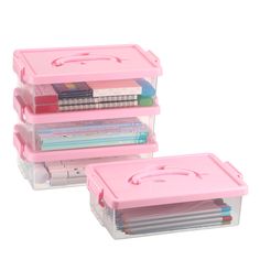 three pink plastic storage boxes with dividers and lids on each side, one has a stack of books in it