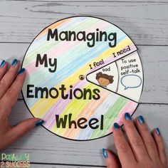 two hands holding up a wheel with the words managing my emotions wheel written on it