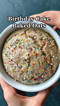 a person holding a cake in a bowl with sprinkles on it and the words birthday cake baked oats