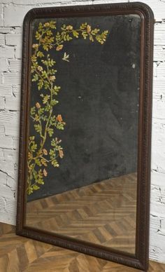 an old mirror is sitting on top of a wooden table next to a brick wall