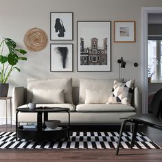 a living room with pictures on the wall and a couch in front of a coffee table